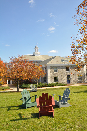 Adirondack chairs outside of dormitory on summer day